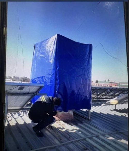 Técnico realizando mantenimiento en un equipo de climatización industrial en cubierta